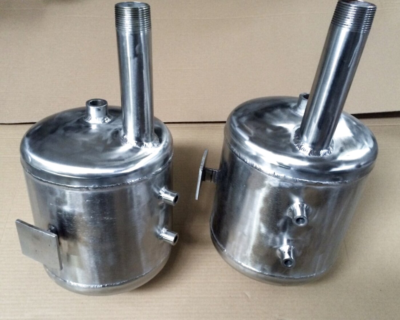 Two small stainless-steel process tanks with fittings