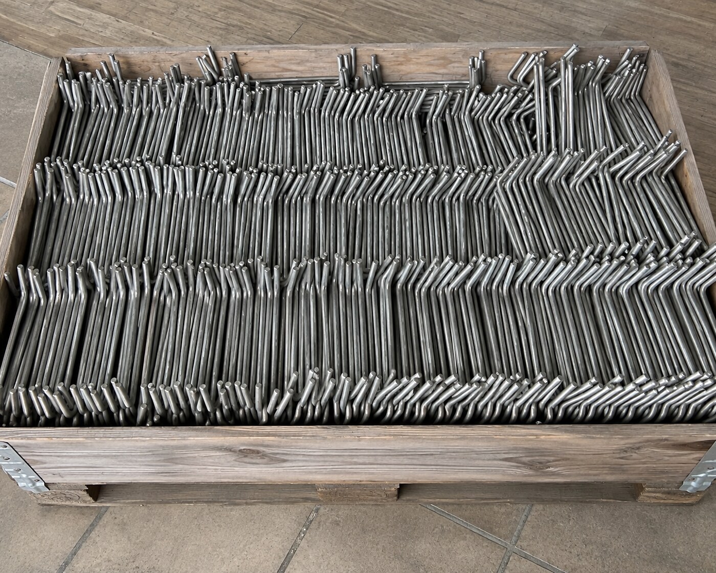 Crate of series-produced stainless-steel bent brackets